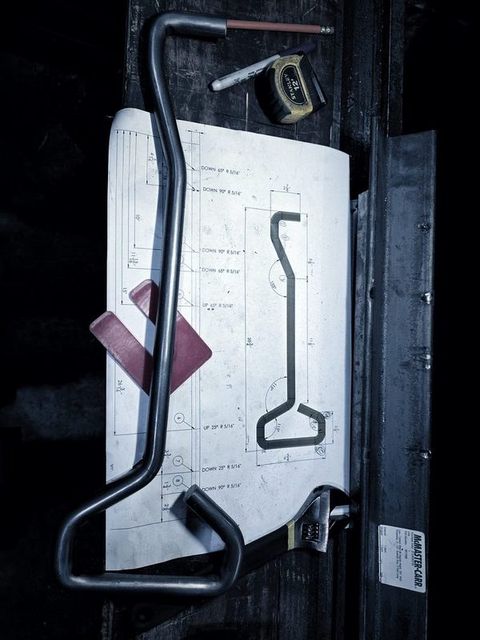 A bent bar handle held against its paper template