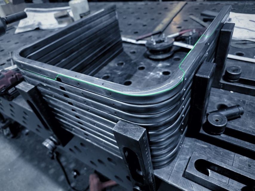 A stack of bent flat bar frames on the fixture table
