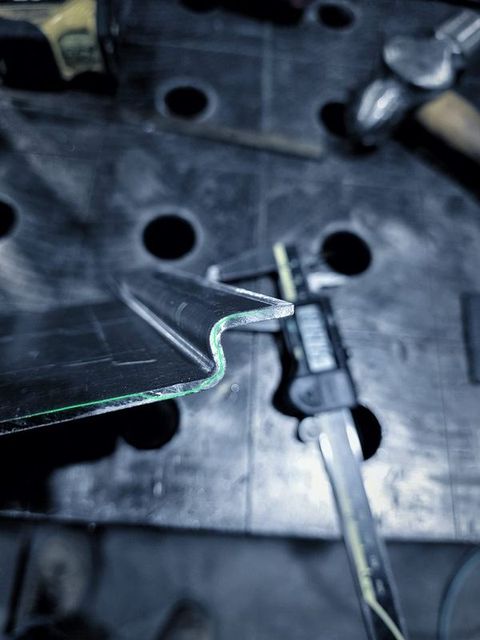 Calipers measure a formed part on the table